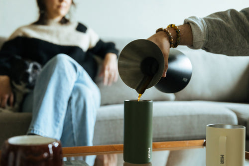 Pouring coffee out of the MiiR Carafe into a MiiR Traveler cup